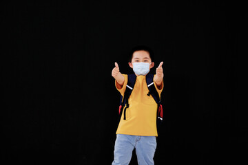 A little boy with a mask held out his thumb