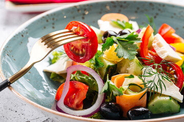 Closeup on eating fresh gourmet greek salad in a bowl