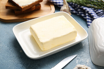 Box with butter and bread on color background, closeup