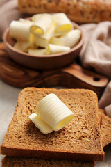 Slices of fresh bread with butter on table, closeup