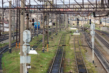 Many railway tracks, semaphores, poles, wires and other devices at a large railway station.