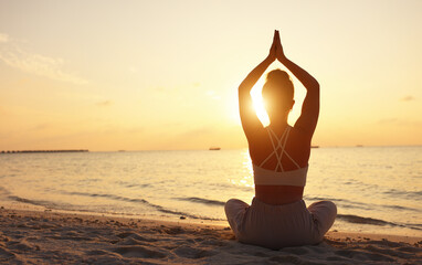 Calm woman meditating on beach at sunset