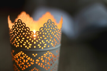 Open book and lit candle on a table. Selective focus.