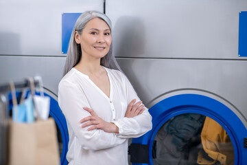 Woman standing near large washing machine