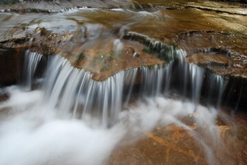 kleiner Wasserfall mit schäumendem Wasser und schönem Stein