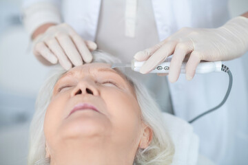 Obraz na płótnie Canvas Mature woman having face beauty treatment in a beauty clinic