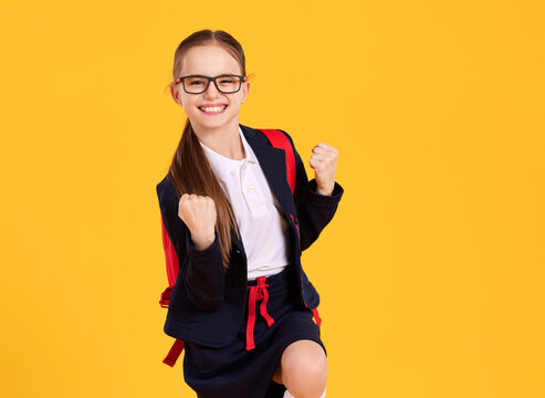 Happy successful schoolgirl celebrating victory