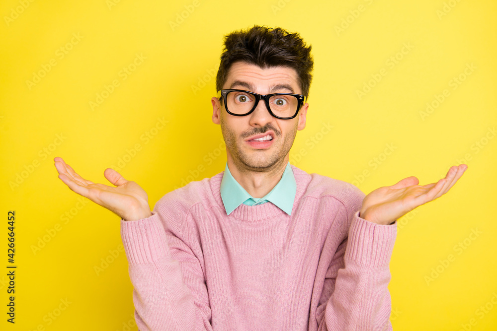 Canvas Prints Photo of young unhappy upset uncertain unsure man in glasses shrug shoulders isolated on yellow color background