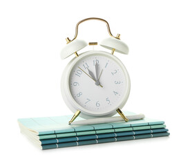 Alarm clock, notebooks and pen on white background