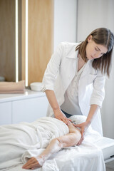 Obraz na płótnie Canvas Female massage therapist working with a female senior patient