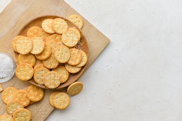 Board with crackers on light background