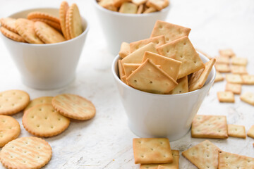 Bowls of crackers on light background