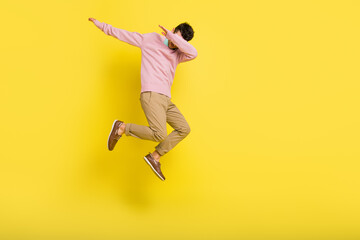 Full size photo of young funky funny man jumping showing dab cover close face isolated on yellow color background