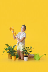 Young female gardener on color background