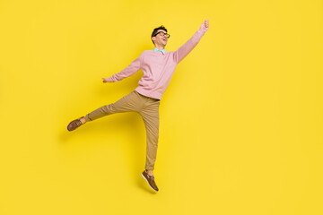 Full length photo of young excited man happy positive smile jump up try to catch umbrella isolated...