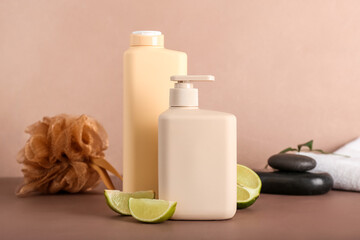 Shower gels and lime slices on color background