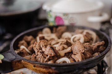 Fried veal liver with onions in a pan. Braised cow and pork liver