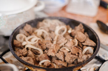 Fried veal liver with onions in a pan. Braised cow and pork liver