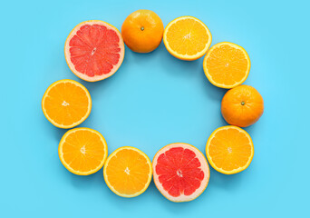 Fototapeta na wymiar Frame made of fresh citrus fruits on color background