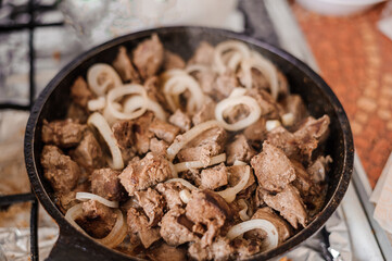 Fried veal liver with onions in a pan. Braised cow and pork liver