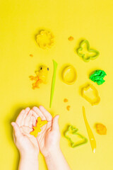 Children hands playing with colorful modeling clay on white background