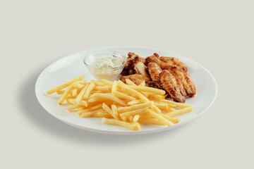 Chicken wings with french fries and garlic mayonnaise and sweet and sour sauce.
