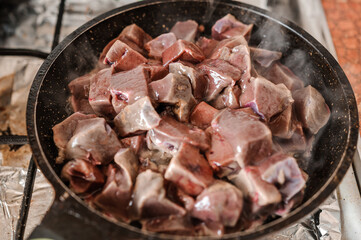 Fried veal liver in a pan. Braised cow and pork liver