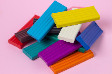 Multi-colored plasticine on a pink background. Educational game. Plasticine set