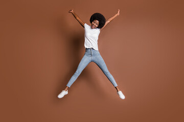 Fototapeta na wymiar Full length body size photo of girl jumping high playful childish overjoyed isolated on brown color background