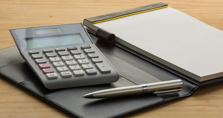 Pen, calculator and notebook on the wooden table. note. paper - obrazy, fototapety, plakaty