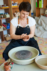 pottery master shows how to work with clay and pottery wheel. Handicraft production.