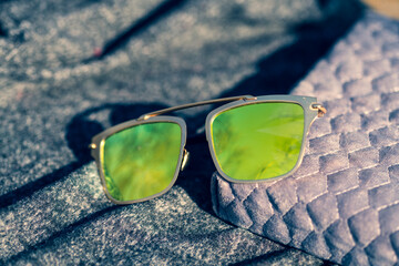 Futuristic sunglasses design with big green lenses closeup shoot outside in a summer day . Selective focus. High quality photo