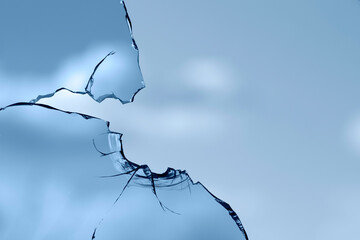 Broken window glass on a background of blue sky