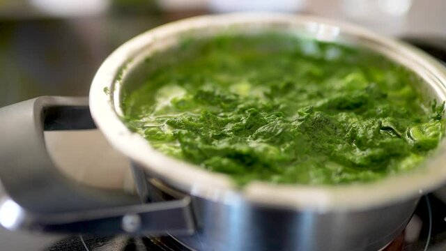 Blattspinat Spinat Gem&uuml;se wird in der Pfanne gekocht. Vegetarisches Essen wird zubereitet. 4K 10 Bit 4:2:2