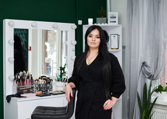 Portrait of make-up artist at workplace in beauty studio. Work process in beauty salon. Getting ready for gala dinner with help of professional stylist.