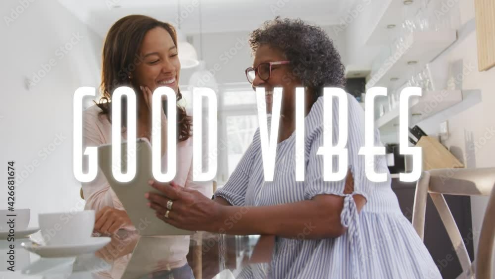 Poster animation of good vibes text over two women using tablet and smiling at home