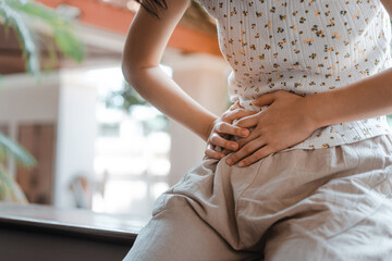 Young adult woman have stomach ill from period menstruation on day time.