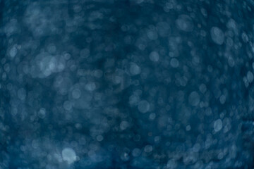 Beautiful blurry sparkles on blue background. Liquid soap in bottle close up