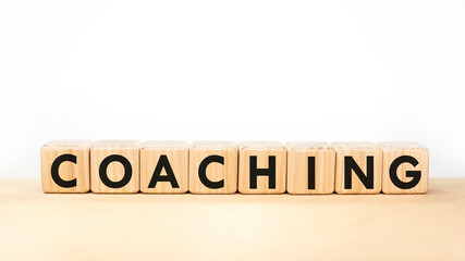 Text COACHING on wooden blocks on white background