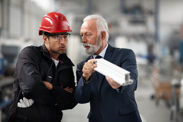 Architect and worker working on project. Colleagues working in factory