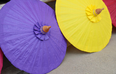 Closeup of blue handmade paper umbrella and other showing on the ground. 