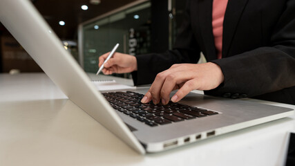 An accountant works with a laptop in his office.