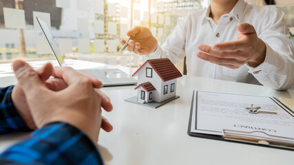 Real estate agents are explaining house designs to clients who come to contact and make contracts within the office.
