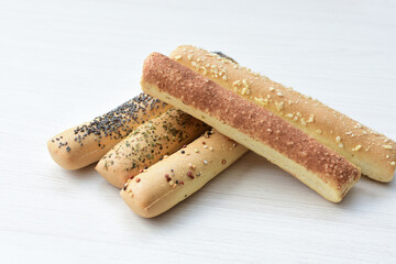 Puff pastry cheese stick, decorated with Parmesan cheese on white wooden background