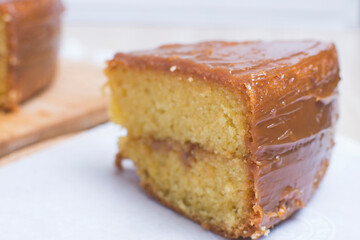 Large vanilla cake, decorated with arequipe on wooden background