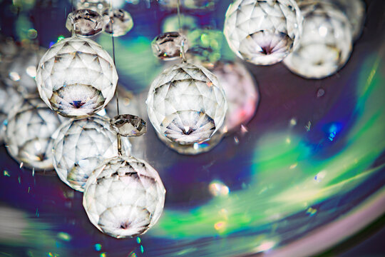 Background image with close up of Hanging opaque crystall balls with blue-green background colors and random flares.