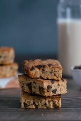 Fototapeta na wymiar Close up of pile of delicious blondie (brownie) on a dark background. Homemade biscuit. Vertical..
