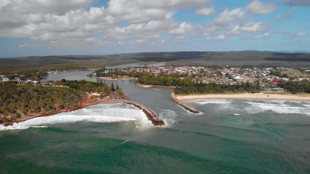 Aerial drone view towards waves hitting the coast of the Evans Head village, in Australia