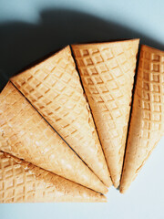 Waffle Sweet ice cream cones. Bouquet of waffle cups on a white shelf, levitation