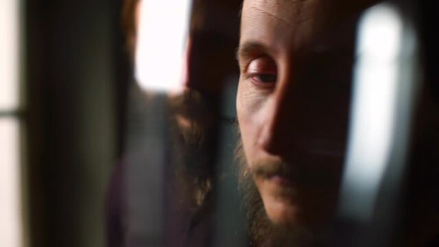 Shooting through the distortion of the portrait of two brothers. They look into the lens camera. Dark key shooting. Artistic portrait.